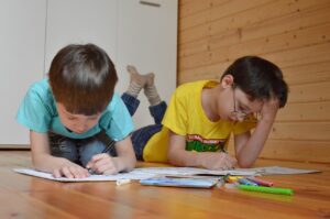 "Parent and child at a table in a cozy home, engaged in a homeschooling activity with books and educational materials, creating an interactive learning experience."